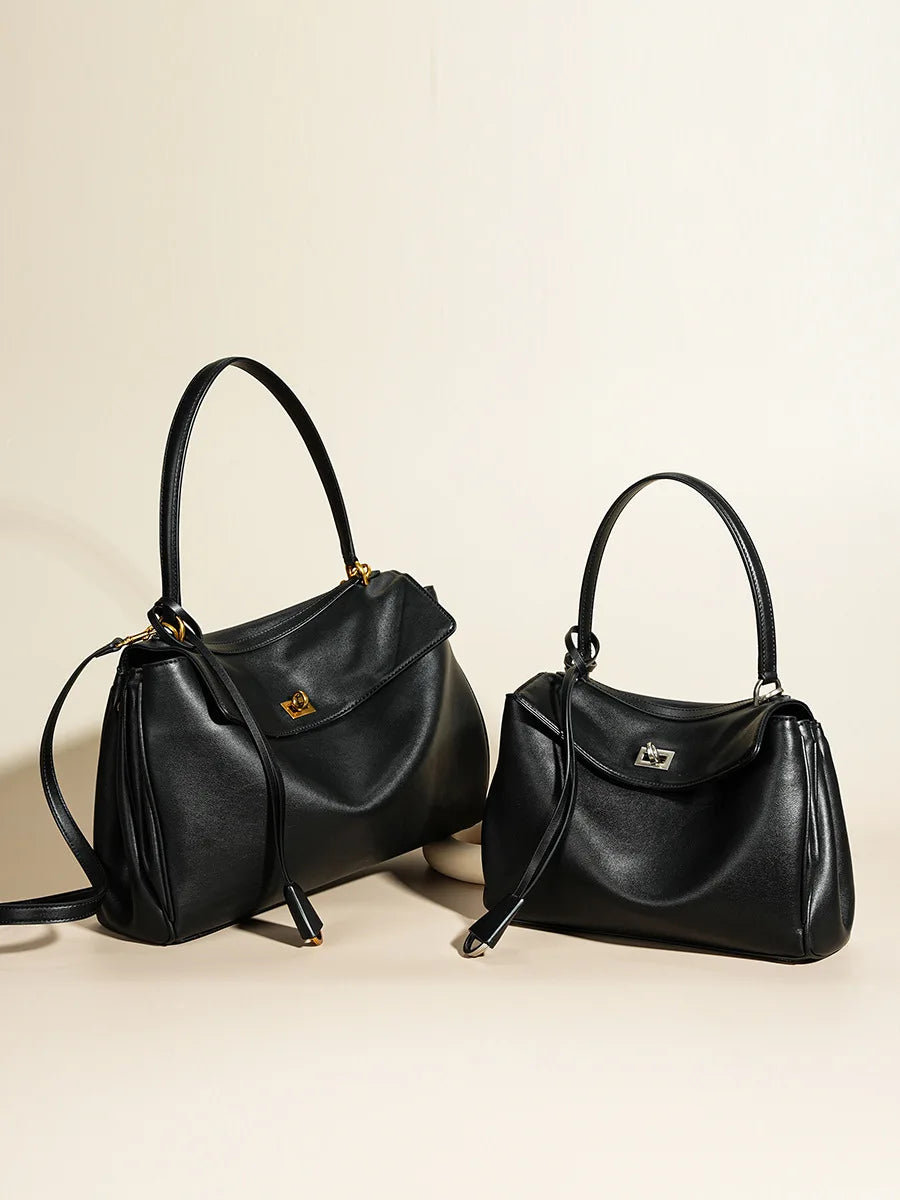 Two black handbags on a beige background