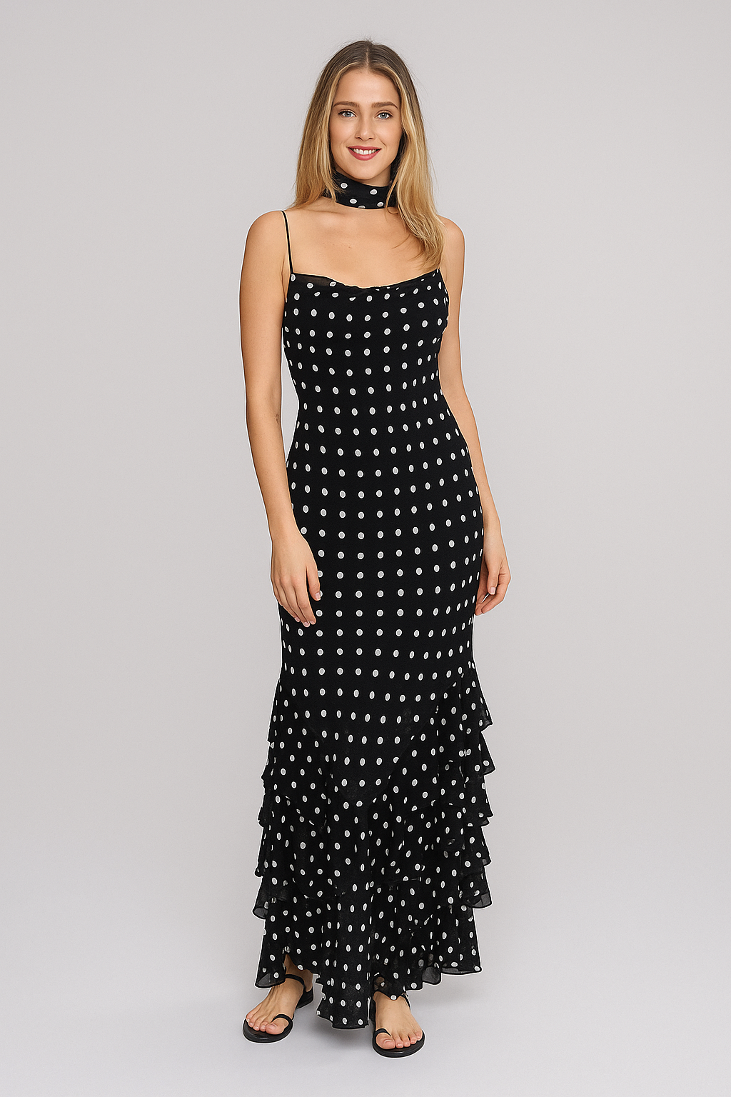 Woman wearing a black polka dot dress on a gray background
