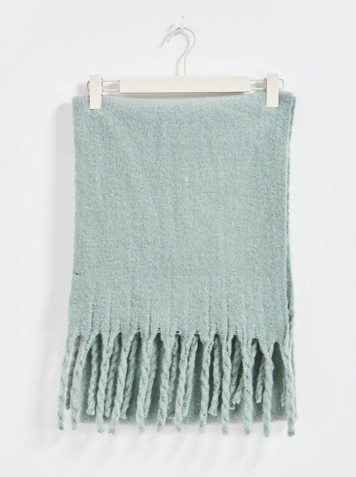 Light blue scarf with fringe on a white background