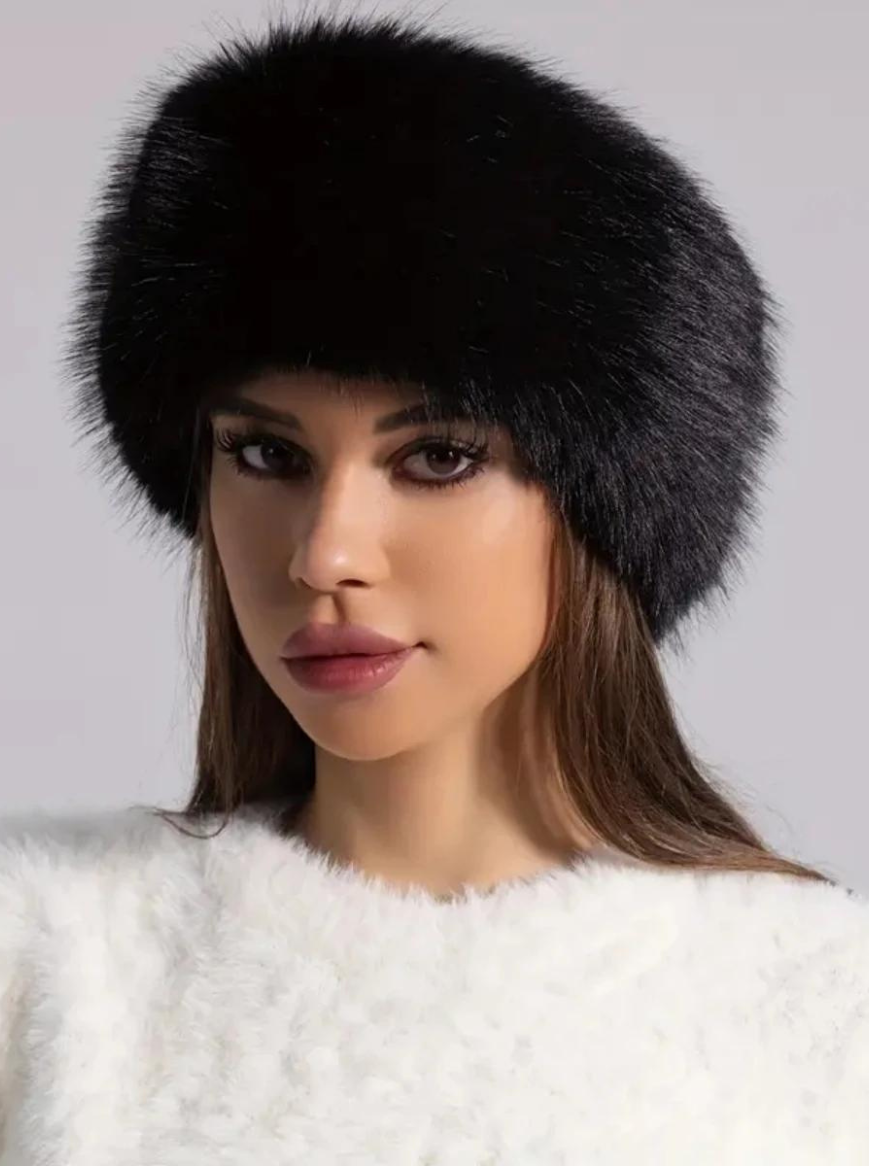 Woman wearing a black fur hat against a neutral background