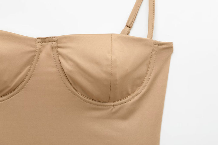 Close-up of a beige tank top with thin straps on a white background