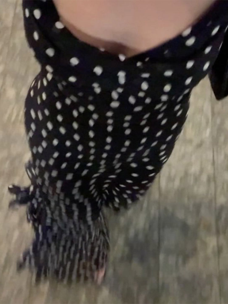 Black scarf with white polka dots on a wooden floor