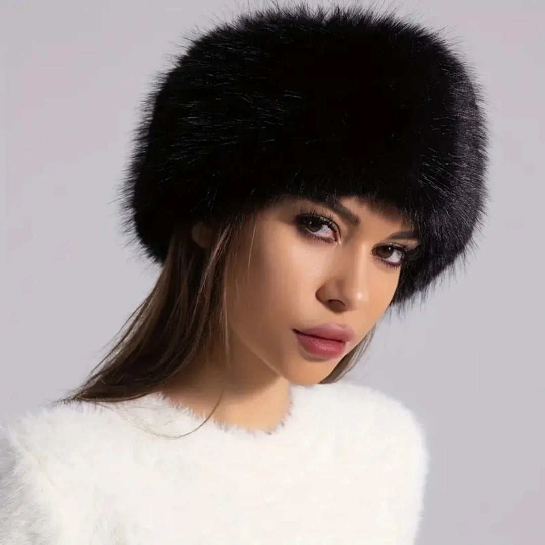 Woman wearing a black fur hat against a gray background