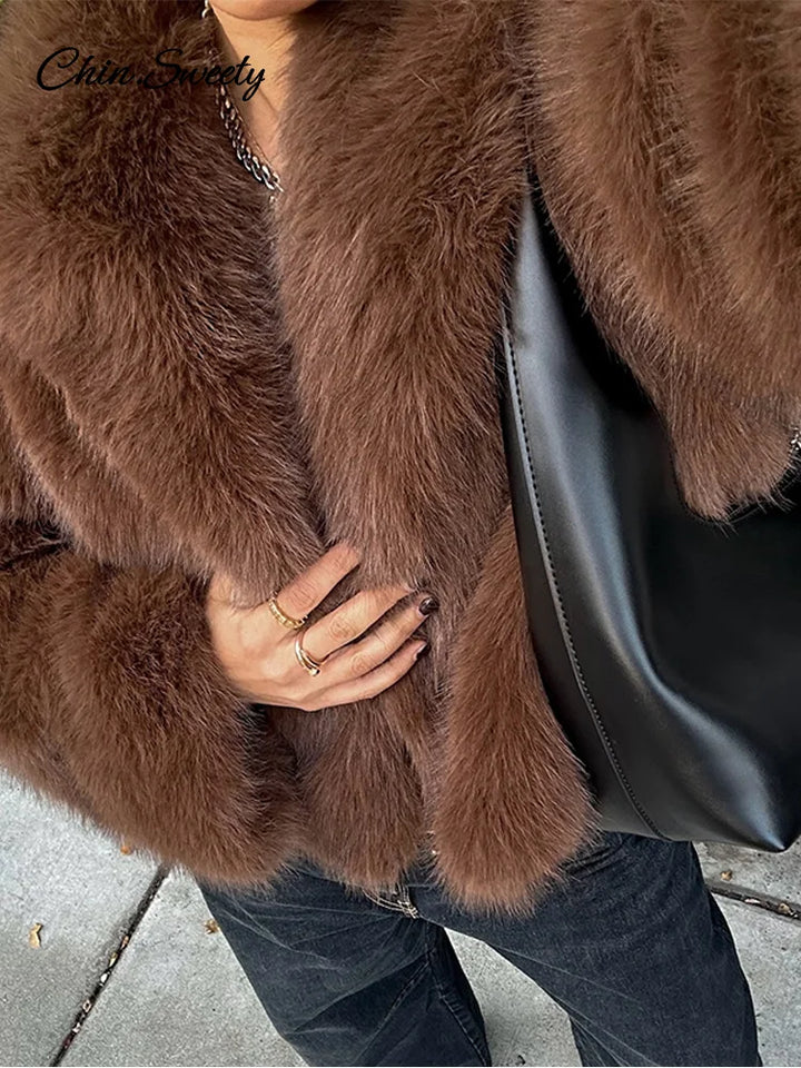 Close-up of a person wearing a brown fur coat with a black handbag.