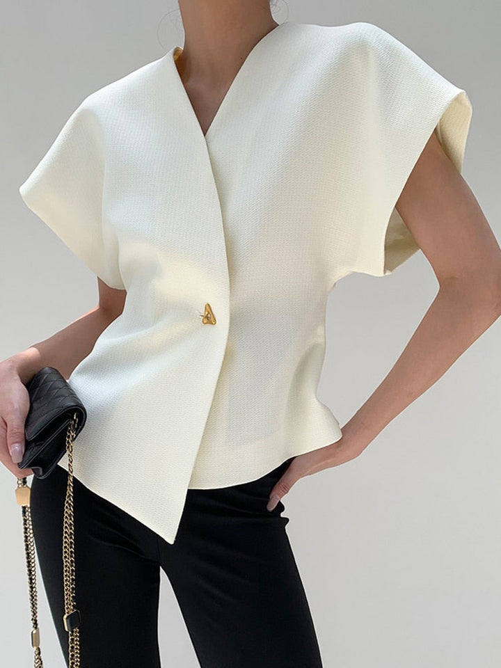 White cape-style top worn by a person on a plain background