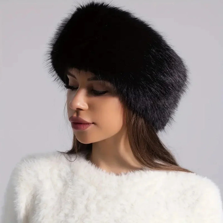 Woman wearing a black fur hat against a gray background